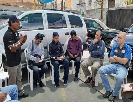 Sesión de capacitación técnica automotriz junto a vehículos